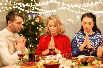 Image showing friends praying before christmas dinner at home