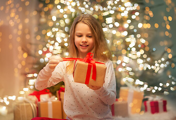 Image showing smiling girl with christmas gift at home