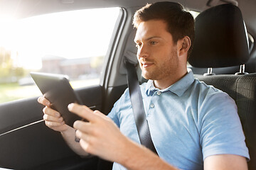 Image showing male passenger using tablet computer in taxi car