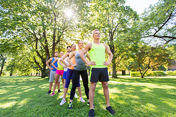 Image showing group of happy friends or sportsmen at summer park