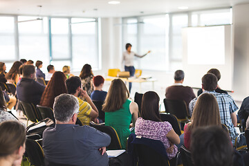 Image showing Speaker giving a talk in conference hall at business meeting event. Rear view of unrecognizable people in audience at the conference hall.