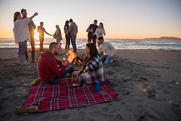 Image showing Couple enjoying with friends at sunset on the beach