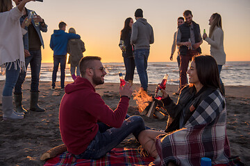 Image showing Couple enjoying with friends at sunset on the beach