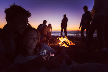 Image showing Couple enjoying bonfire with friends on beach