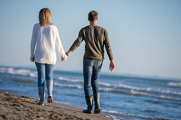 Image showing Loving young couple on a beach at autumn sunny day