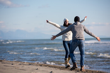 Image showing Loving young couple on a beach at autumn sunny day