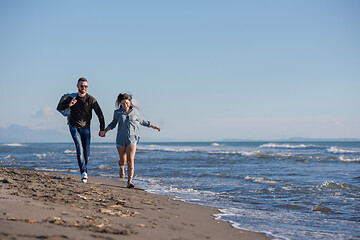 Image showing Loving young couple on a beach at autumn sunny day