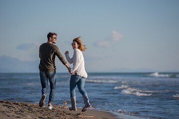 Image showing Loving young couple on a beach at autumn sunny day