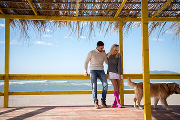 Image showing Couple with dog enjoying time on beach