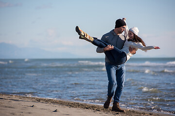 Image showing Loving young couple on a beach at autumn sunny day