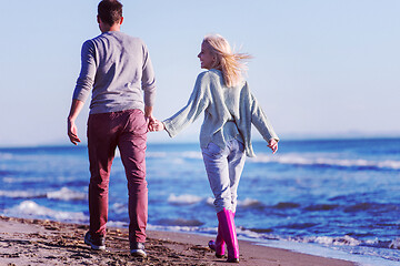 Image showing Loving young couple on a beach at autumn sunny day