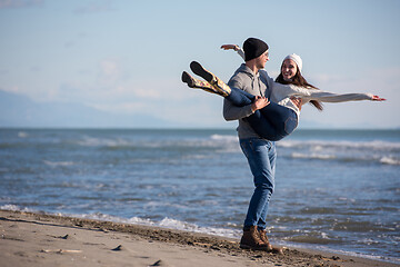 Image showing Loving young couple on a beach at autumn sunny day