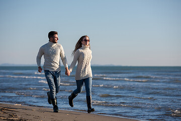 Image showing Loving young couple on a beach at autumn sunny day