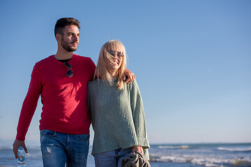 Image showing Loving young couple on a beach at autumn sunny day