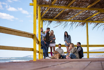 Image showing Group of friends having fun on autumn day at beach