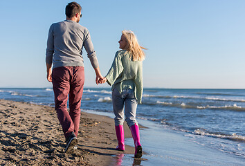 Image showing Loving young couple on a beach at autumn sunny day