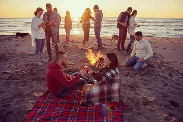 Image showing Couple enjoying with friends at sunset on the beach