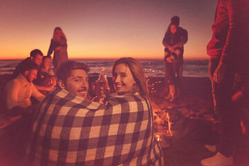 Image showing Couple enjoying with friends at sunset on the beach