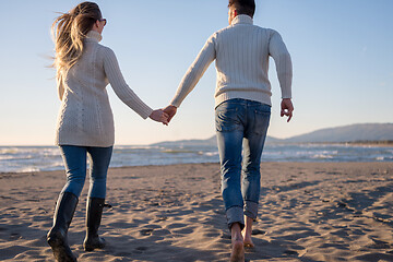 Image showing Loving young couple on a beach at autumn sunny day