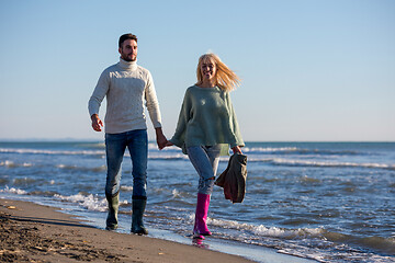 Image showing Loving young couple on a beach at autumn sunny day