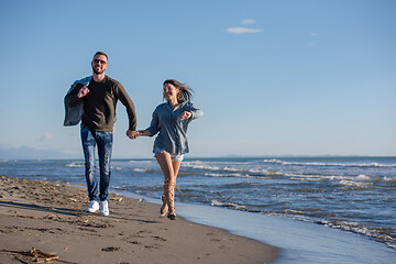 Image showing Loving young couple on a beach at autumn sunny day