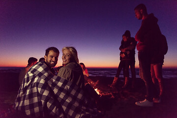 Image showing Couple enjoying with friends at sunset on the beach