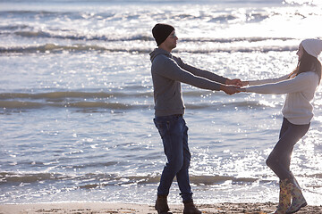 Image showing Loving young couple on a beach at autumn sunny day