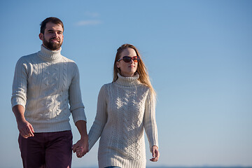 Image showing Loving young couple on a beach at autumn sunny day