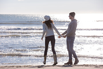 Image showing Loving young couple on a beach at autumn sunny day