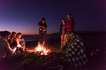 Image showing Couple enjoying with friends at sunset on the beach