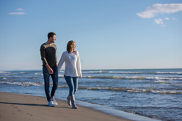 Image showing Loving young couple on a beach at autumn sunny day