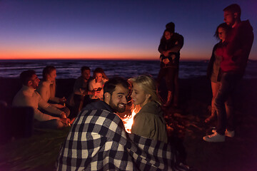 Image showing Couple enjoying with friends at sunset on the beach