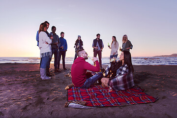 Image showing Couple enjoying with friends at sunset on the beach