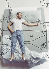 Image showing Top view photo of young man sleeping in a big white bed and his dreams