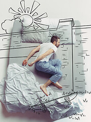 Image showing Top view photo of young man sleeping in a big white bed and his dreams