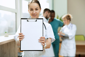 Image showing Beautiful smiling doctor over hospital background