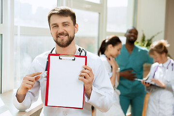 Image showing Beautiful smiling doctor over hospital background