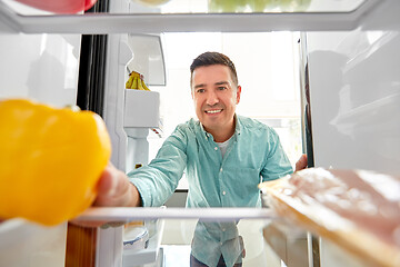 Image showing man taking vegetable from fridge at home kitchen