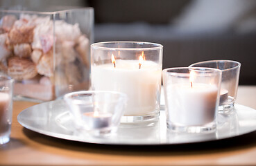 Image showing burning white fragrance candles on tray on table
