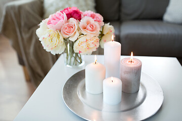 Image showing candles burning on table and flowers at cozy home