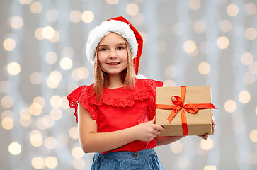 Image showing smiling girl in santa hat with christmas gift