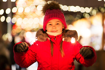 Image showing happy girl with sparklers at christmas market