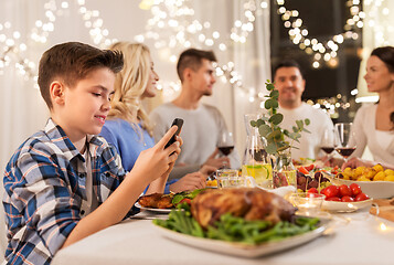 Image showing boy with smartphone at family dinner party