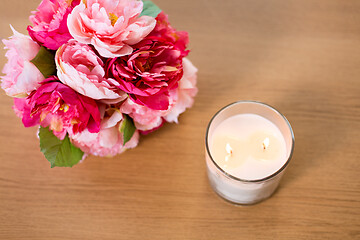 Image showing burning fragrance candle and flower bunch on table