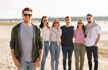 Image showing happy man with friends on beach in summer