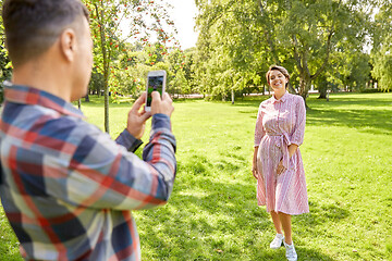 Image showing couple photographing by smartphone in park