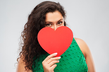 Image showing happy woman in green dress holding red heart