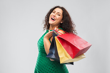 Image showing happy woman in green dress with shopping bags