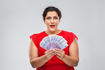 Image showing happy woman holding thousands of money banknotes