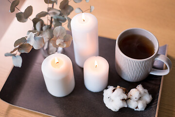 Image showing candles, tea and branches of eucalyptus on table
